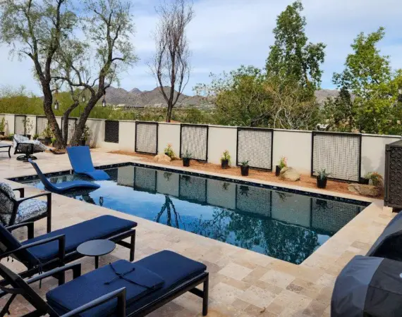 Luxurious backyard pool area with comfortable lounge chairs, outdoor seating, and stunning mountain views, designed by Valley Design Group.